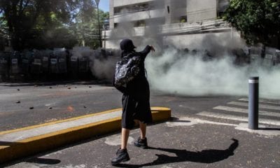 Una joven lanza piedras a elementos de la policía mientras protestaban frente a la casa en representación de Jalisco. Foto: Cuartoscuro