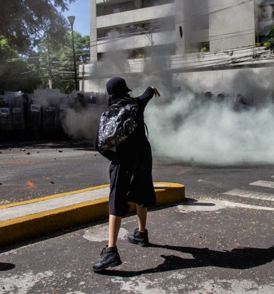 Una joven lanza piedras a elementos de la policía mientras protestaban frente a la casa en representación de Jalisco. Foto: Cuartoscuro