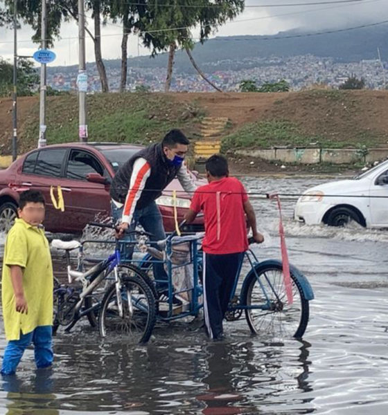 Niños transportan en triciclo a vecinos afectados las lluvias