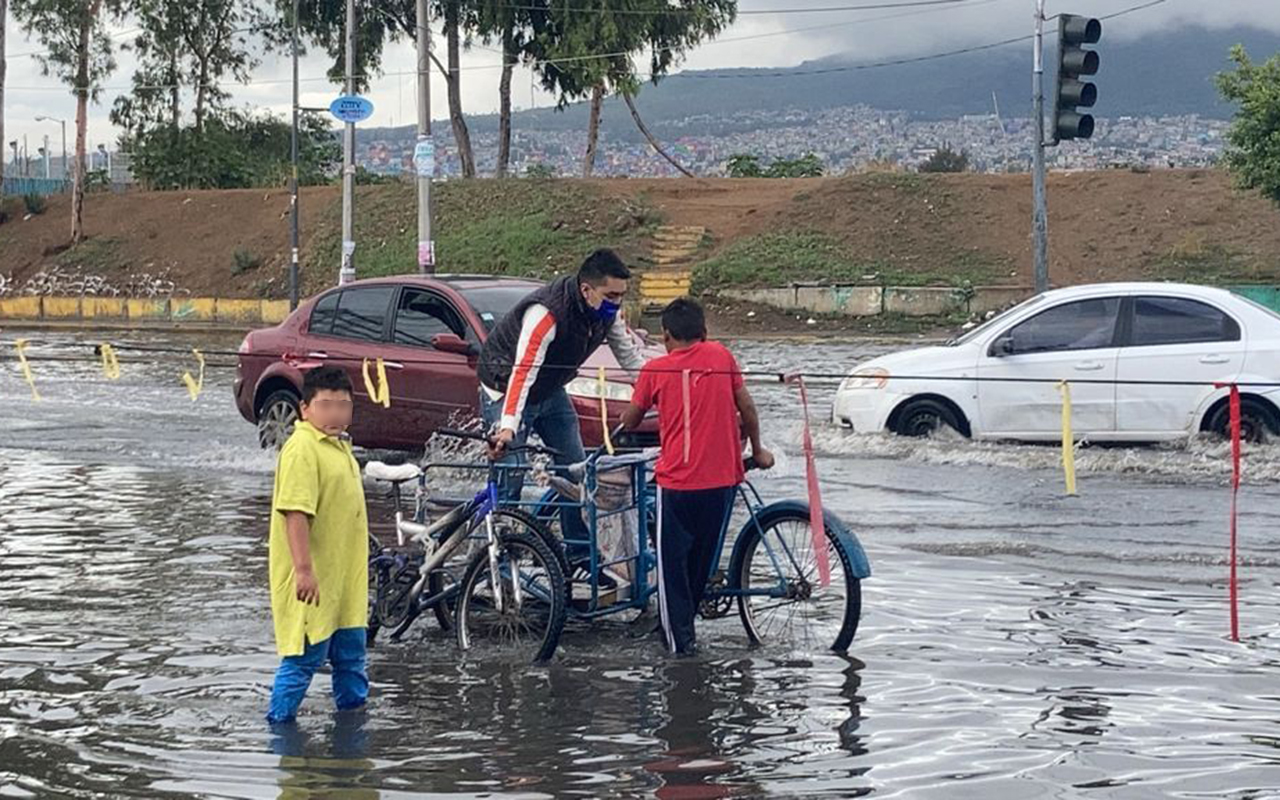 Niños transportan en triciclo a vecinos afectados las lluvias