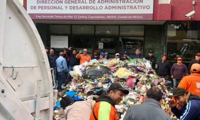 Trabajadores de limpia exigen pago de bono; tiran basura afuera de oficinas